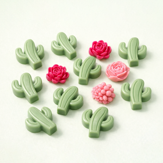 Green cactus and pink flower-shaped wax melts on a white background